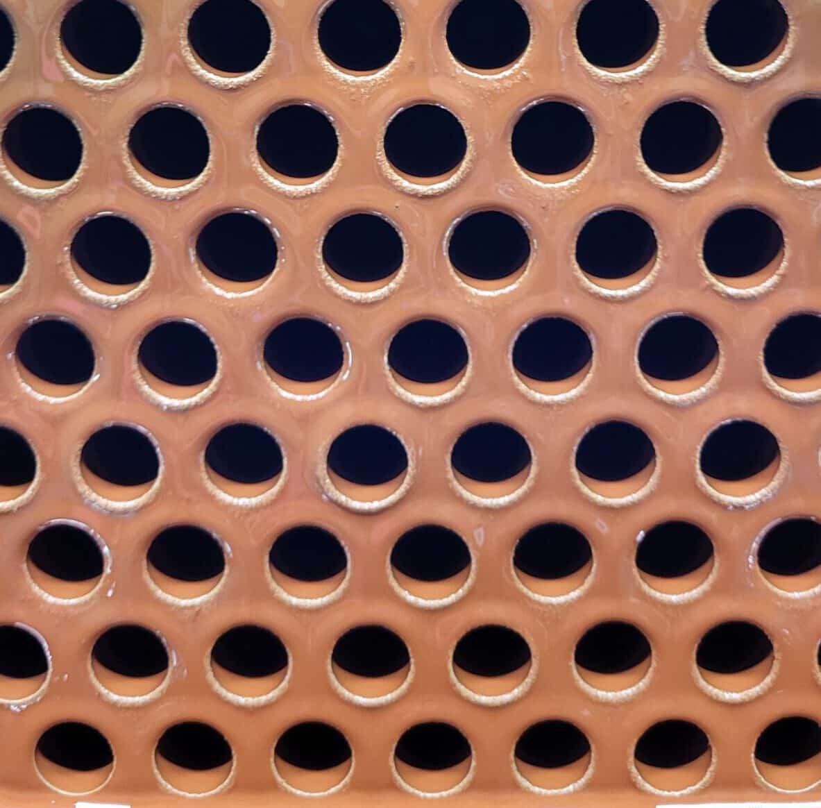 Pijpenplaat van een shell and tube warmtewisselaar, roodbruin gecoat rondom elke buis